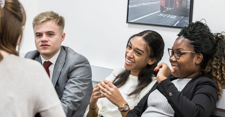 Post 16 students sitting in the common room talking and smiling