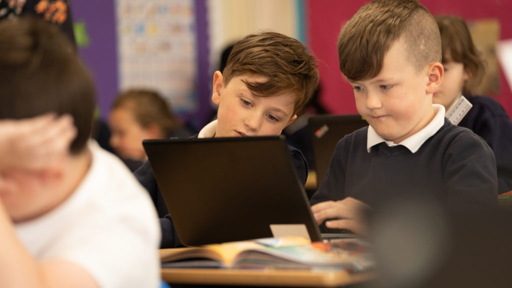 Two boys looking at a computer screen during a lesson